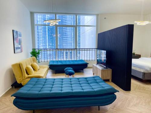a living room with a blue couch and a bed at Lovely Private Contemporary Residential Apartment - 201 in Abu Dhabi