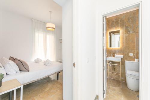 una camera da letto con un letto e un bagno con un lavandino di ISG Apartments Zaragoza-FREE PARKING a Siviglia