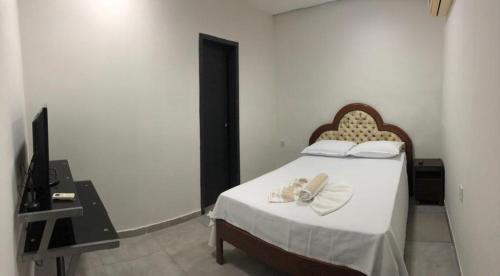 a bedroom with a bed with two towels on it at Hotel Cuiabá in Cuiabá
