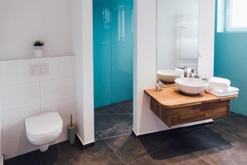 La salle de bains est pourvue de toilettes blanches et d'un lavabo. dans l'établissement Louis & Louise Penthouse I Digital Check In, à Brême