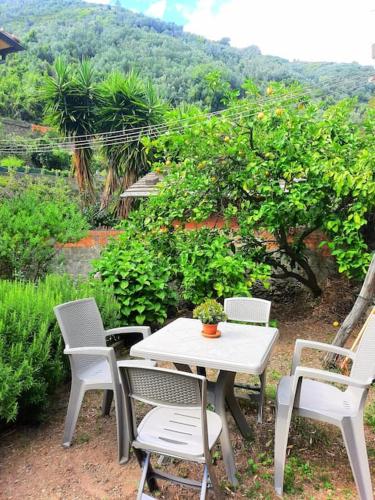 uma mesa e cadeiras brancas e uma mesa e cadeiras em Il limoneto dei Cinque Sensi,apartment with garden em Vernazza