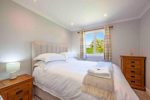 Un dormitorio con una gran cama blanca y una ventana en Cuilreigh, North Connel, en Oban