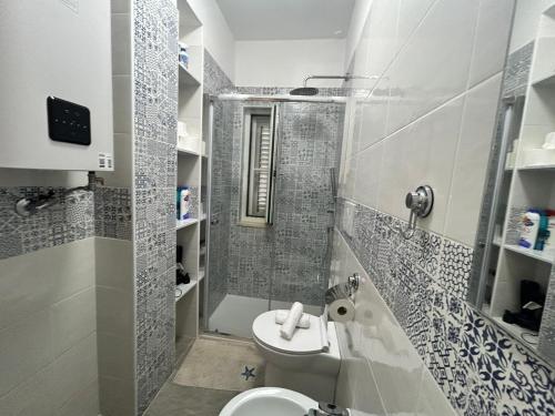 a bathroom with a toilet and a shower and a sink at Villaggio al mare in Manfredonia