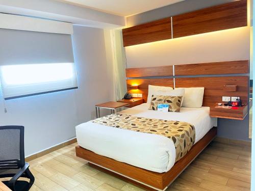 a bedroom with a large bed and a window at Sleep Inn Mexicali in Mexicali