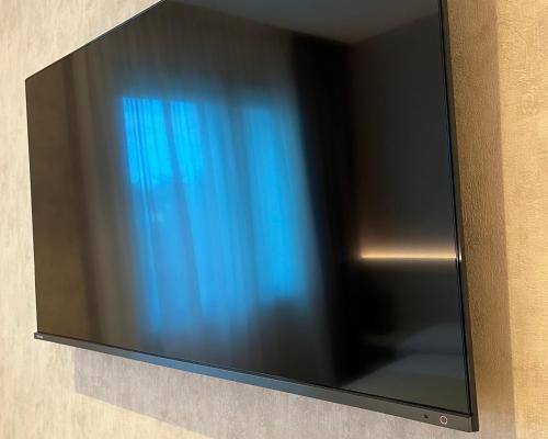 TV de pantalla plana colgada en la pared en Hotel Poppi, en Mira