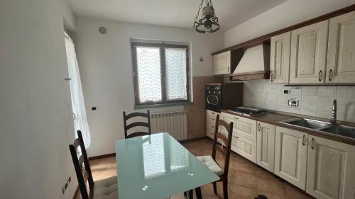 eine Küche mit einem Tisch, Stühlen und einem Waschbecken in der Unterkunft La casa della Nonna in Figline Valdarno