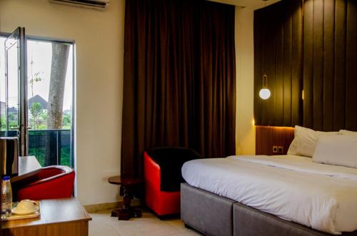 Habitación de hotel con cama y ventana en Moratel Hotels, en Port Harcourt