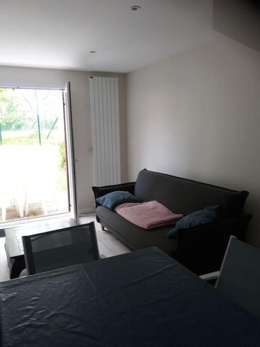 un salon avec un canapé et un salon avec une fenêtre dans l'établissement Les cottages du golf à Ploemel, à Ploemel