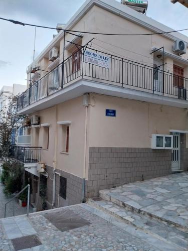 a building with a balcony on the side of it at HERMOUPOLI ROOMS in Ermoupoli