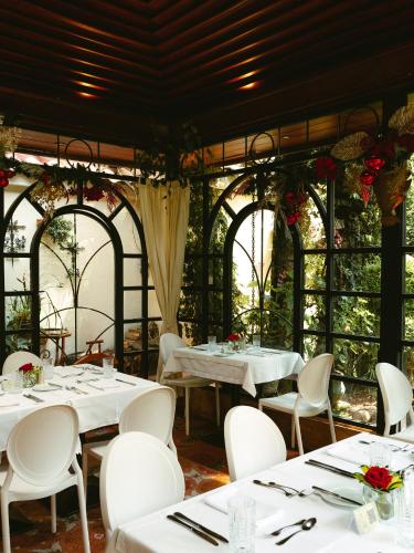 a dining room with white tables and white chairs at Mansion Alcazar in Cuenca