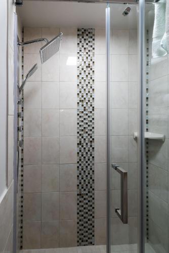 a shower with a glass door in a bathroom at Le Chateau de Pierre in Quebec City