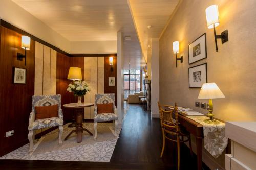 a living room with a table and chairs and a desk at Mansion Alcazar in Cuenca
