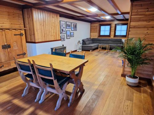 a living room with a wooden table and chairs at Daffodils in Enscherange