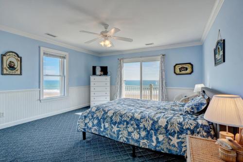 een slaapkamer met blauwe muren en een bed en een raam bij 110 N Permuda Wynd in North Topsail Beach