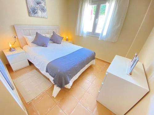 1 dormitorio con 1 cama grande y 2 mesas en Soleada PBaja con Gran Terraza a pie de piscina Altaona Golf en Murcia