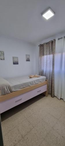 1 dormitorio con cama y ventana en vivienda Acerina, en Las Palmas de Gran Canaria