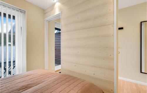 a bedroom with a wooden accent wall at Stunning Apartment In Gudhjem With Wifi And 1 Bedrooms in Gudhjem