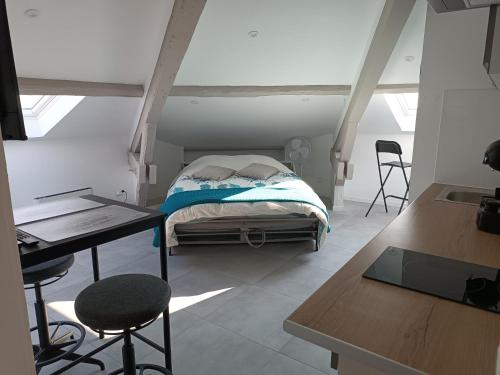 Studio Anthėor, vue mer في سانت رافائيل: غرفة نوم بسرير وطاولة وكراسي