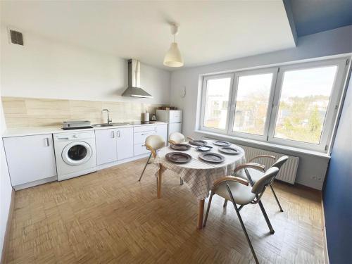 eine Küche mit einem Tisch und einer Waschmaschine in der Unterkunft Apartamenty Orłowo in Gdynia