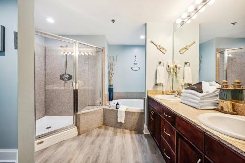 a bathroom with a tub and a sink and a shower at Laketown Wharf #824 by Nautical Properties in Panama City Beach