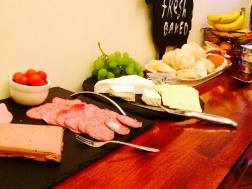 a table with cheese and meats and bread and fruit at Serendipity House in Derry Londonderry