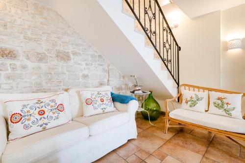 una sala de estar con 2 sofás blancos y una pared de piedra. en Bella Bari en Bari