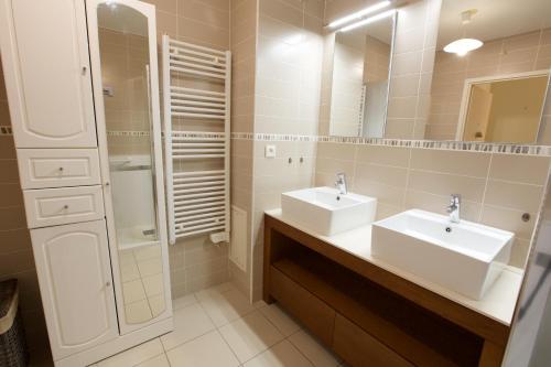 La salle de bains est pourvue de 2 lavabos, d'une douche et d'un miroir. dans l'établissement * Capbreton * Hossegor * Golf * Parking * Famille, à Capbreton