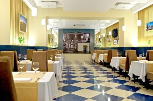 a restaurant with tables and chairs in it at Teatralny Hotel in Zaporozhye