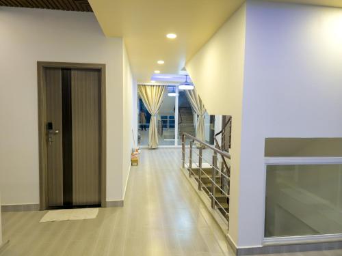 a hallway of a building with a door and stairs at Arora View in Maafushi