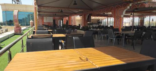 a restaurant with wooden tables and chairs in a building at Loaloat maadi Hostel "Cornich Elnile" in Cairo
