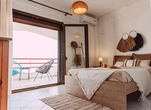 1 dormitorio con 1 cama grande y balcón en Sea Breeze Paradise en Palioúrion