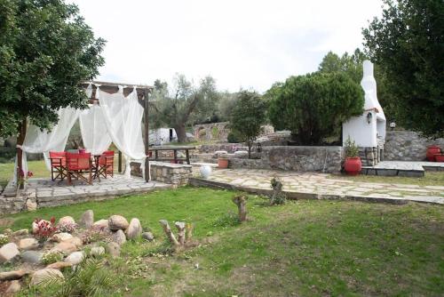 a garden with a table and chairs and a building at Sea Breeze Paradise in Paliouri