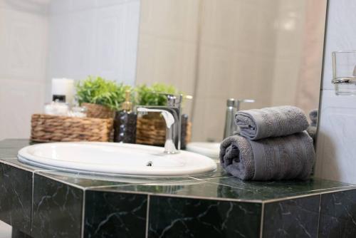 La salle de bains est pourvue d'un lavabo et de serviettes sur un comptoir. dans l'établissement Sea Breeze Paradise, à Paliouri