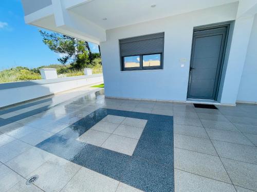 uma casa vazia com piso em azulejo e duas janelas em Vixen Apartment em Theologos