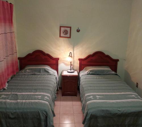 two beds sitting next to each other in a room at CASA JOAQUÍN HOSTAL in Oaxaca City