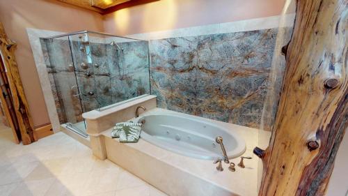 a bathroom with a tub and a glass shower at Seneca Lodge in Cooperstown