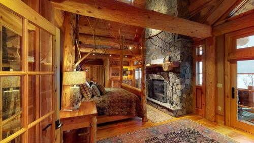 庫珀斯敦的住宿－Seneca Lodge，一间卧室配有一张床和一个石头壁炉