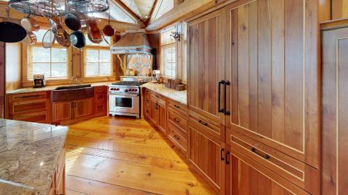 a kitchen with wooden cabinets and a stove at Seneca Lodge in Cooperstown