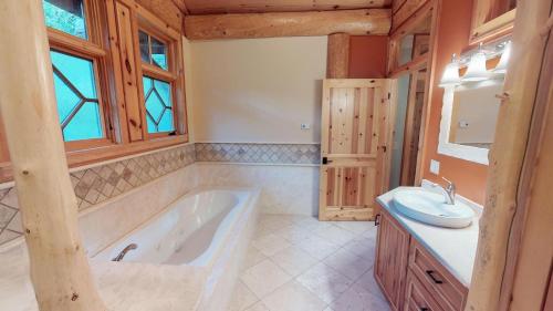 a large bathroom with a tub and a sink at Oneida Lodge North in Cooperstown