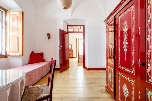 a room with a bed and a table and a door at Casa Garcia in Amareleja