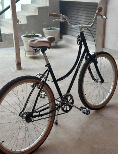 a black bike parked on a sidewalk next to stairs at MID-498 Centro in Mérida