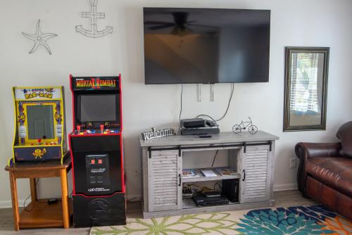 a living room with a television and a video game at OceanView Oasis - Relax with Hot Tub, Breakfast, Fire Pit & Putting Green! in Panama City Beach