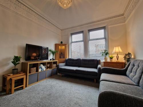 a living room with two couches and a tv at DYSA Abbey House in Blackpool