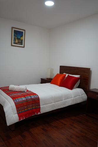 a bedroom with a large bed with red pillows at Hotel Colonial - Casa Francisco in Quito