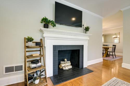 a living room with a fireplace with a flat screen tv above it at Fayetteville Vacation Rental - 1 Mi to Downtown! in Fayetteville