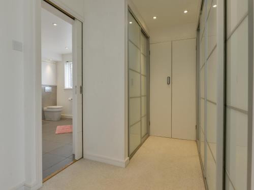 a bathroom with white walls and glass doors at Skerries in Dartmouth