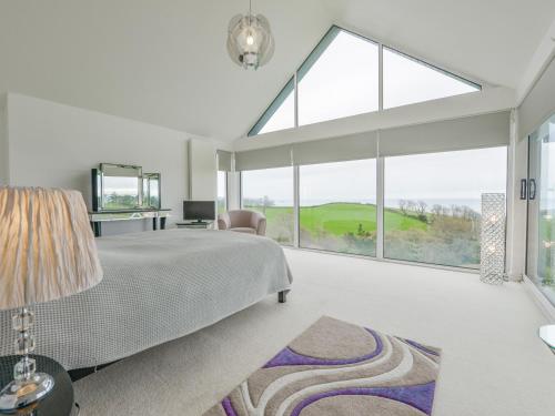 a bedroom with a bed and a large window at Skerries in Dartmouth