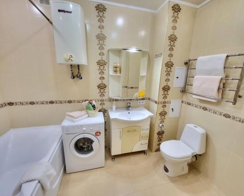 ein Badezimmer mit einer Waschmaschine und einem Waschbecken in der Unterkunft Kiev Apartment in Kiew