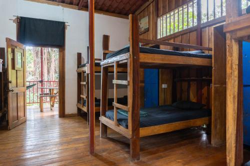 a room with three bunk beds in a house at Burnt Toast Surfcamp in Nosara