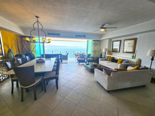 a living room with a table and a dining room at Amazing views, beachfront Grand Venetian in Puerto Vallarta